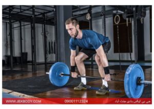 مردی در باشگاه در حال انجام حرکت ددلیفت کلاسیک